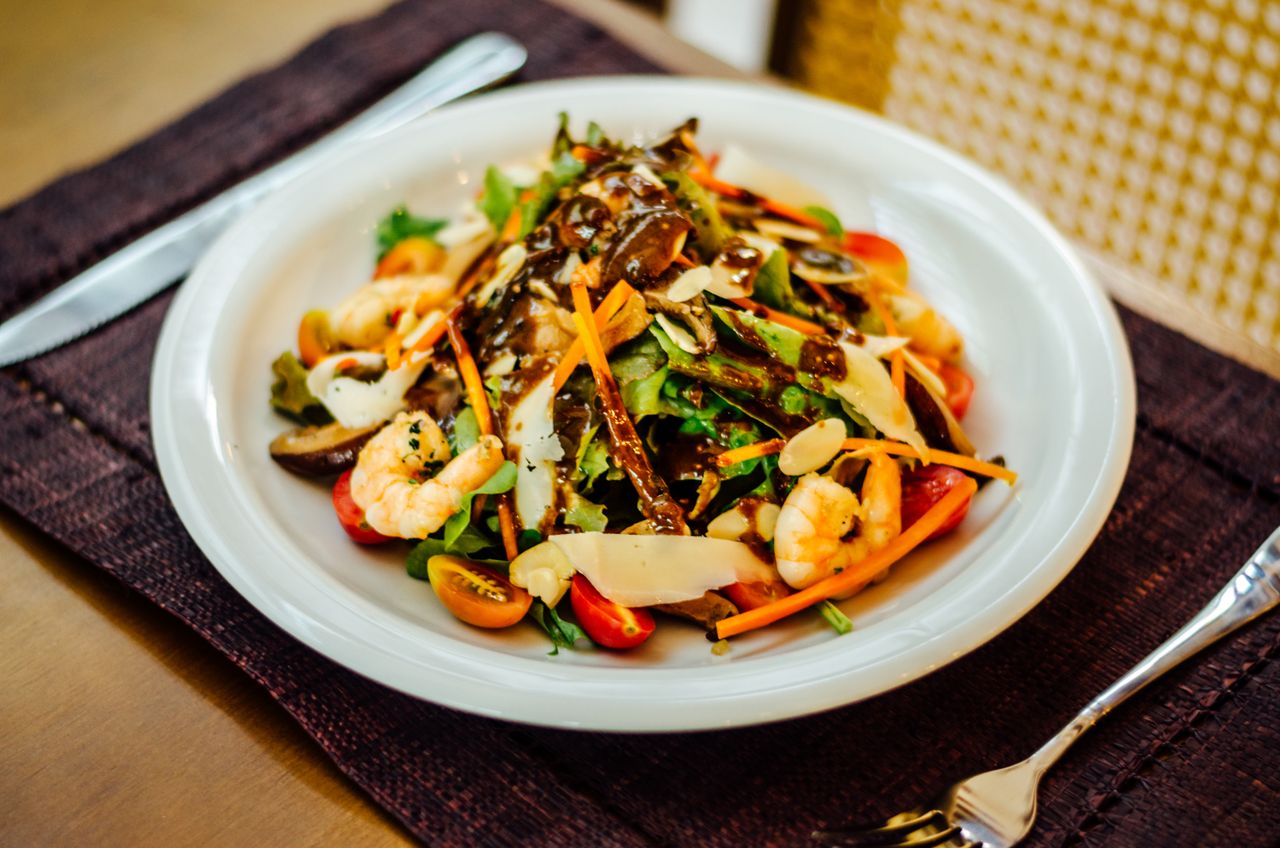 hero-img-01 Colorful shrimp salad with fresh vegetables, capturing a healthy and vibrant meal in Pipa, Brazil.