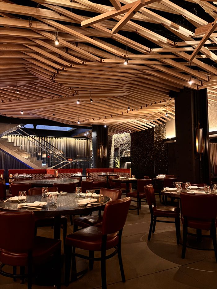 gallery-1 Elegant restaurant interior featuring wooden ceiling and red leather seating.