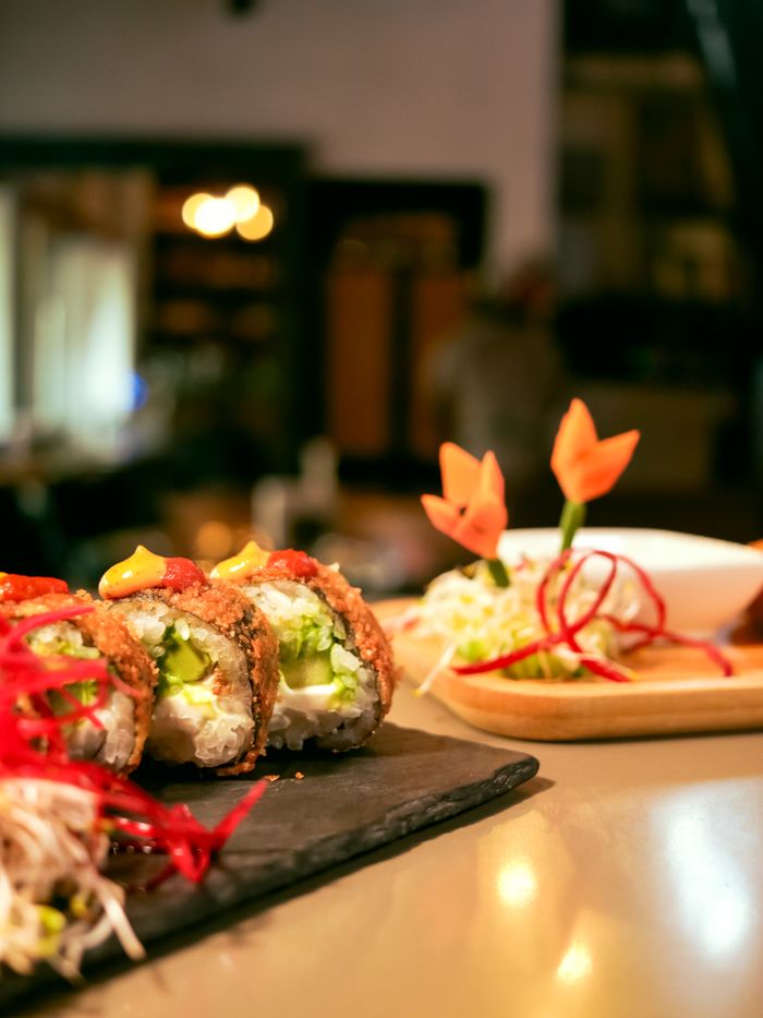 why-choose-us Close-up of gourmet sushi rolls with elaborate garnish, perfect for culinary themes.