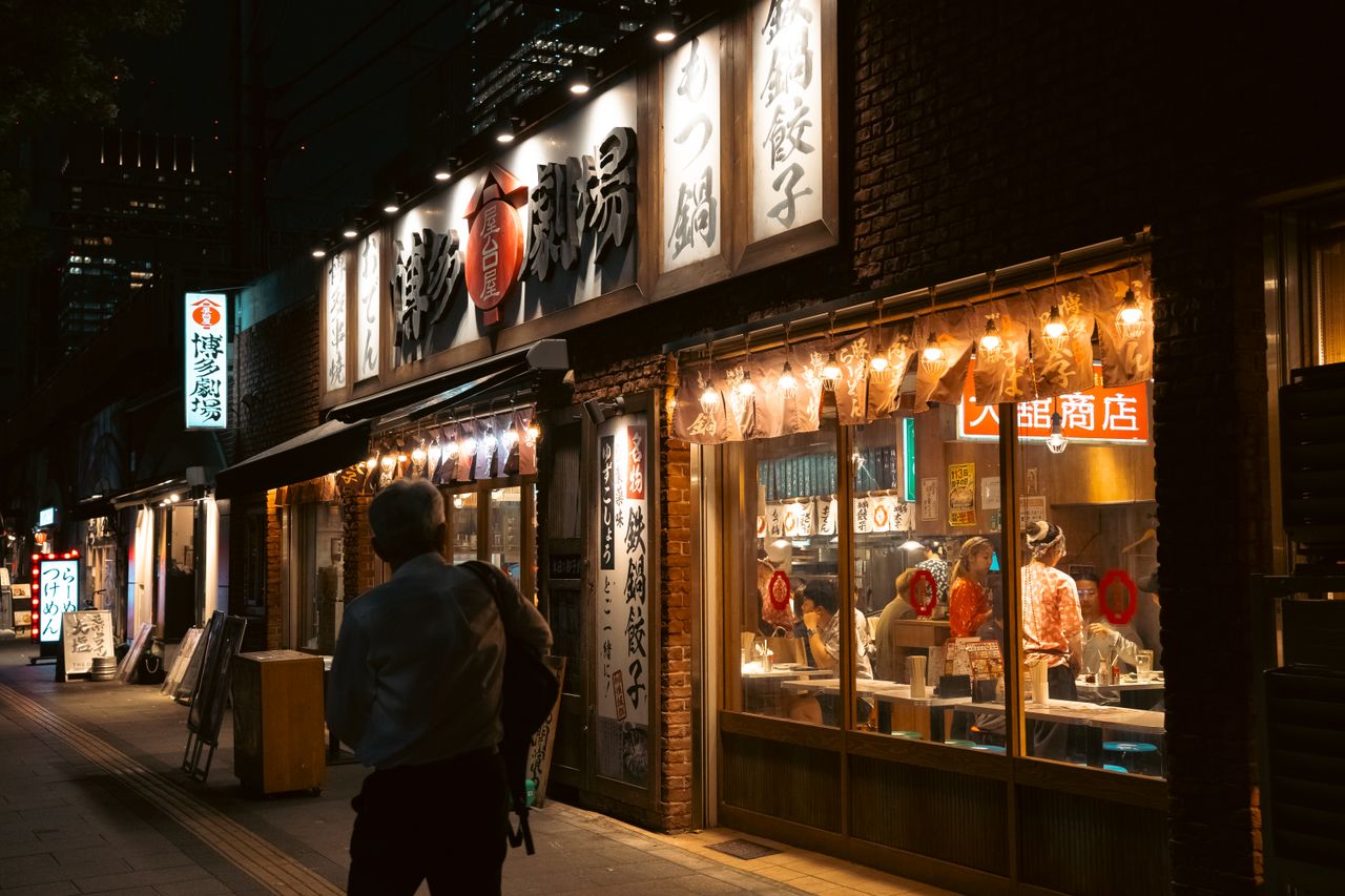 about-01 A vibrant Tokyo street scene at night showcasing a traditional Japanese restaurant.
